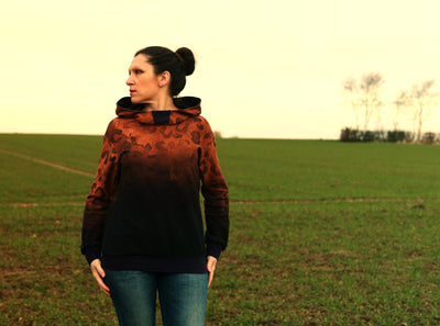 Kalix Hoodie Damen – Schwarz mit orangefarbenem Farbverlauf auf dem Feld